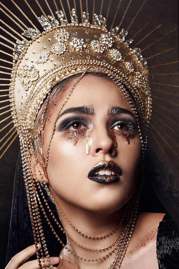 Woman in gold crown with gold tears